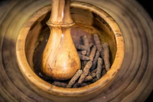 Kampot pepper being ground in wooden mortar and pestle