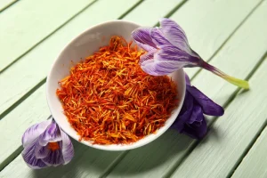 White bowl of saffron with a flower leaning against it
