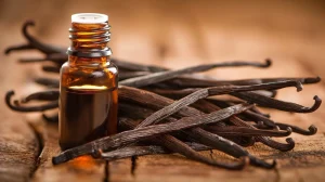 Vanilla beans beside a small jar of vanilla.