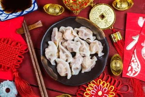 Chinese dumplings in a bowl with chopsticks.