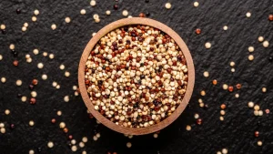 Wooden bowl filled with gluten free grains on a black background