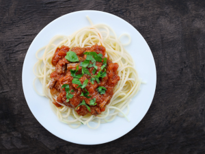 Bolognese on spaghetti on a black background.
